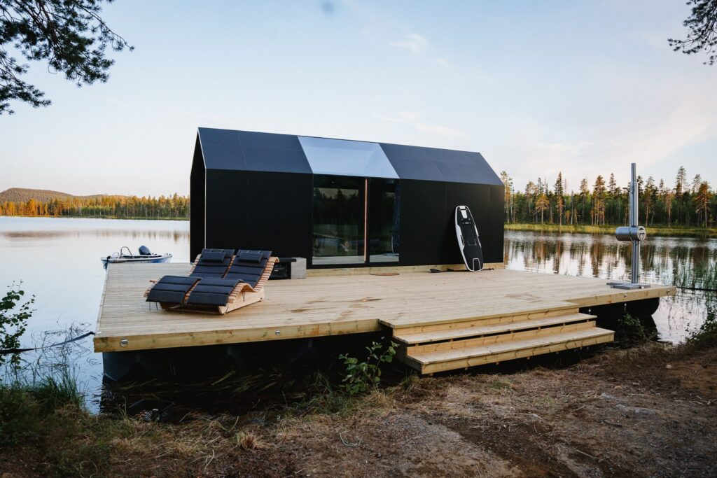 Kleines Haus auf einer Plattform des Ufloat-Systems: ein Hausboot mit Terrasse in Schweden
